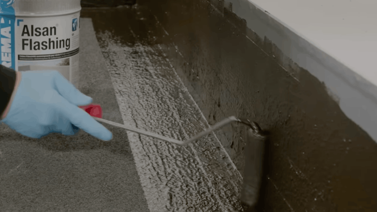 Application d'ALSAN FLASHING au rouleau sur un relevé d'étanchéité