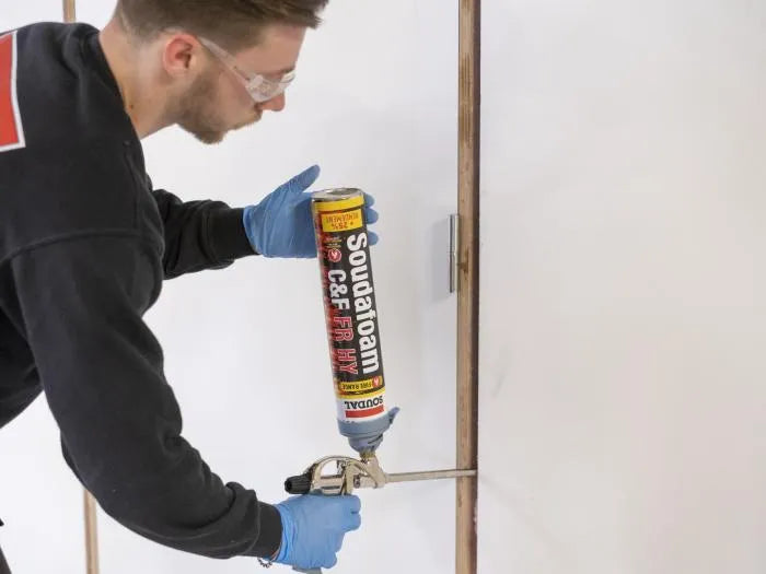 Calfeutrement d'un bâti de porte à la mousse coupe-feu Soudafoam FR HY appliquée au pistolet